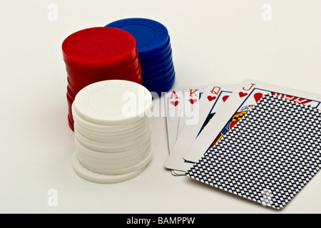 Potenzialmente vincente mano di poker accanto a tre pile di poker chips Foto Stock