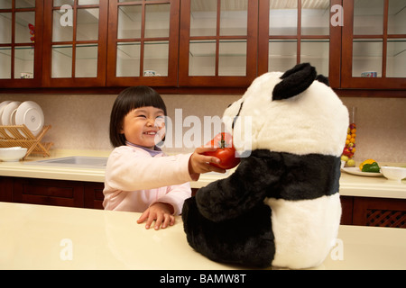 Una giovane ragazza di aver cercato di sfamare la sua panda ripiene un pomodoro Foto Stock