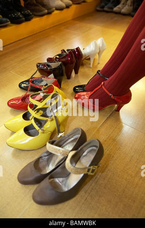 Donna cerca su scarpe in un negozio Store Foto Stock