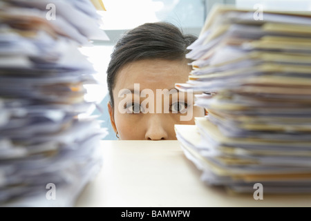 Imprenditrice tra due pile di lavoro Foto Stock