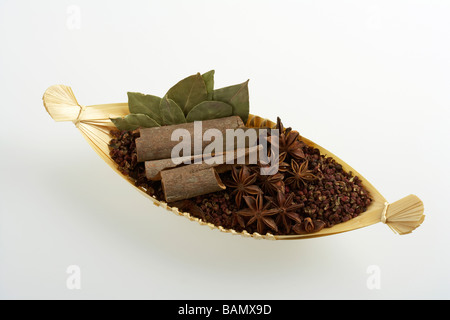 Anice stellato, cannella, spezie e foglie di alloro in un cesto tessuto Foto Stock