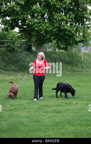 Giovane donna ama passeggiare i suoi due gatti nel Parco Foto Stock