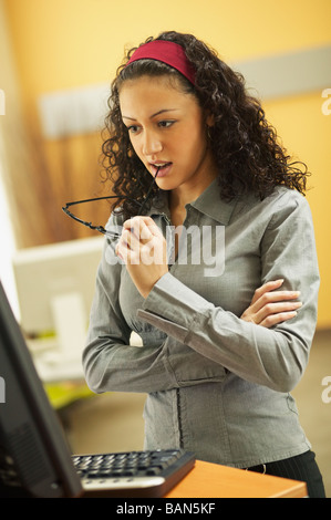 Giovane imprenditrice masticare la fine dei suoi bicchieri Foto Stock