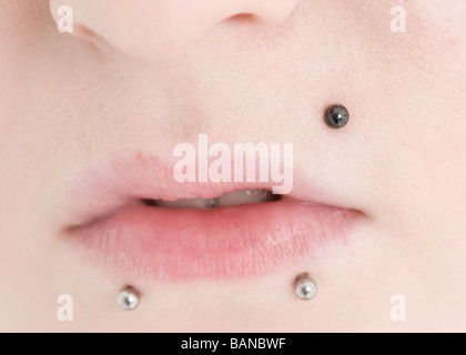 Labbro piercing in una giovane donna di bocca in close up Foto Stock