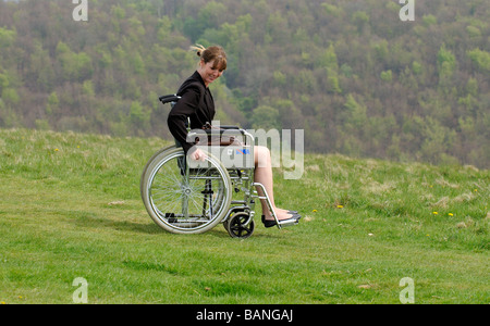 Donna seduta su una sedia a rotelle nella campagna inglese UK Foto Stock