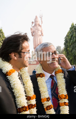 Uomini d'affari indiani indossare collane floreali in attrazione turistica Foto Stock