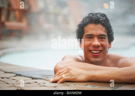 Uomo seduto in una vasca calda Foto Stock