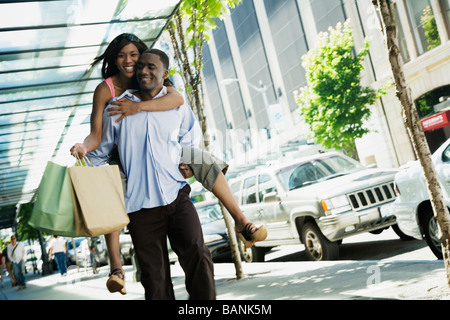 L'uomo africano dando ragazza piggyback ride Foto Stock