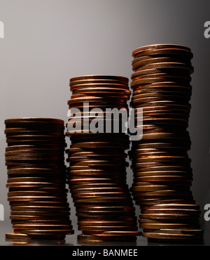Tre pile di pochi centesimi su sfondo grigio con evidenziazione sulla sinistra Foto Stock