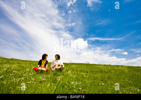 Asian giovane suonando la batteria in Prato Foto Stock