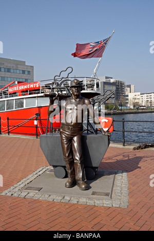 Scultura in bronzo di un minatore di carbone, di fronte alla Helwick Lightship a Cardiff Docks Wales UK. Cultura gallese Foto Stock