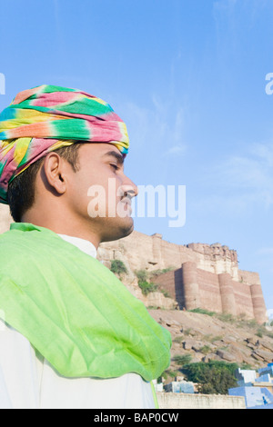 Profilo laterale di un uomo con il fort in background, Meherangarh Fort, Jodhpur, Rajasthan, India Foto Stock