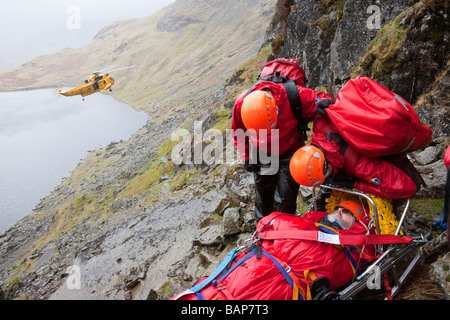 Un viandante con un composto di frattura della gamba viene trattata da Langdale Ambleside Mountain Rescue Team in facile canalone su Pavey Ark Foto Stock