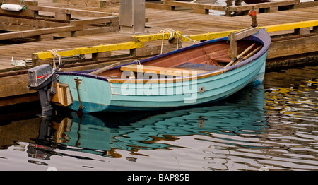 Un piccolo blu barca da pesca legata a un molo Foto Stock