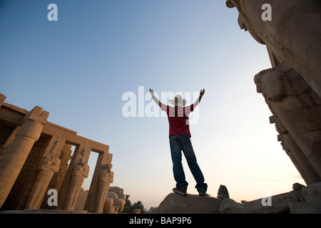 A Luxor Egitto; l'uomo con il cappello con i bracci sollevati visitando il Ramesseum Foto Stock