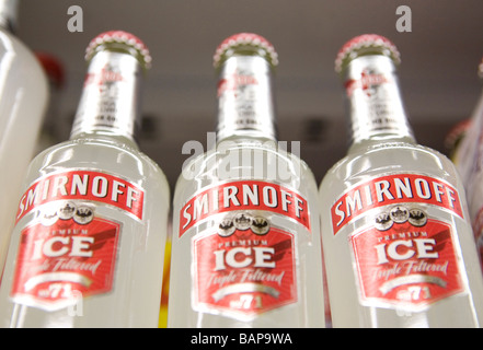 Bottiglie di Smirnoff Ice sul ripiano in una licenza off Foto Stock