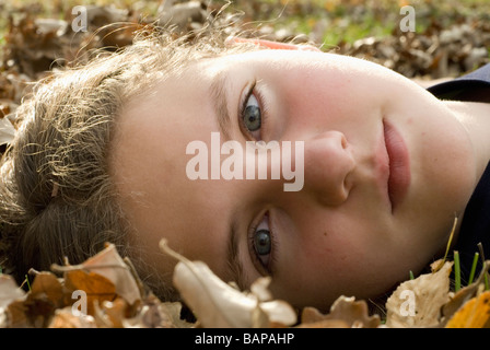 Ragazza distesa in foglie, Winnipeg, Canada Foto Stock