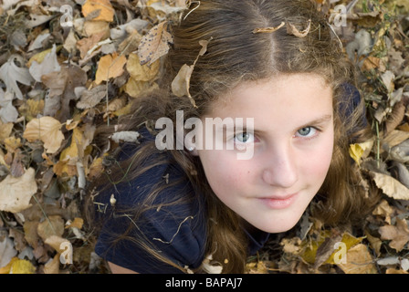 Teen ragazza distesa in foglie, Winnipeg, Canada Foto Stock