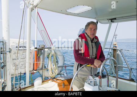 Uomo al timone di una barca a vela al largo della costa della California vicino a San Francisco Foto Stock