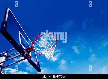 Fotografia all'aperto di un pallone da basket net hoop shot contro profondo cielo blu sullo sfondo Foto Stock