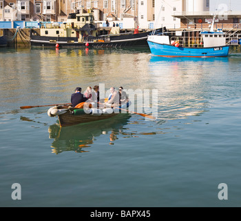 La gente in barca a remi taxi traghetto che va da un lato di Weymouth Harbour per l'altro. Il Dorset. Regno Unito. Foto Stock