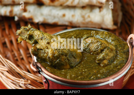 Saag Pollo è un piatto di pollo che è preparato da cucinare con spinaci lungo con spezie indiane e può essere servito con il roti Foto Stock