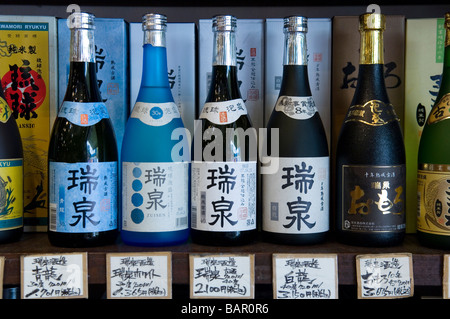 Bottiglie di Sake sul display in uno dei molti turisti in negozi di souvenir in Heiwa Dori mercato. Naha, Okinawa, in Giappone Foto Stock