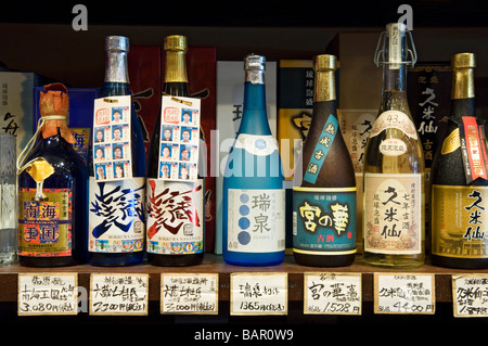 Bottiglie di Sake sul display in uno dei molti turisti in negozi di souvenir in Heiwa Dori mercato. Naha, Okinawa, in Giappone Foto Stock