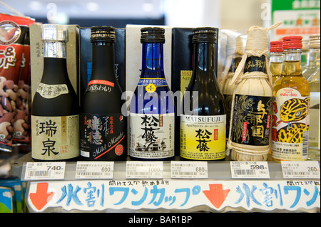 Bottiglie di Sake sul display in uno dei molti turisti in negozi di souvenir in Heiwa Dori mercato. Naha, Okinawa, in Giappone Foto Stock