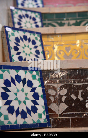 Zellij tessere mosaico esposti per la vendita su scale piastrellate in "Arte Naji' fabbrica di ceramiche nella medina di Fes el-Bali, Fes Marocco Foto Stock
