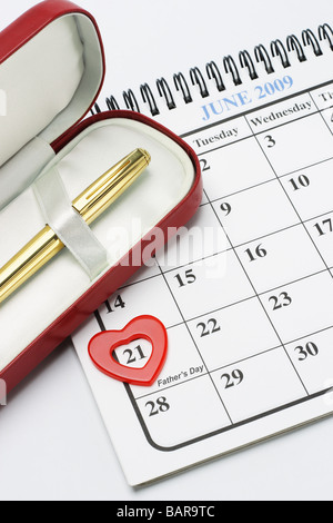 Penna stilografica in confezione regalo e una forma di cuore simbolo sulla pagina del calendario mostra il 21 giugno padre s day Foto Stock