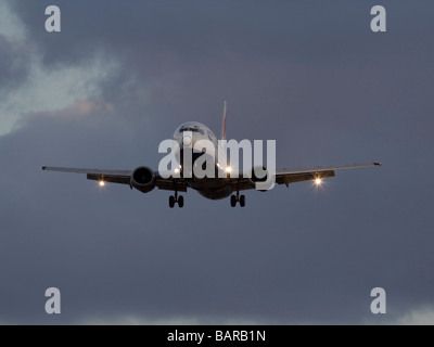 British Airways Boeing 737-400 jet aereo in arrivo in un cielo nuvoloso al tramonto Foto Stock