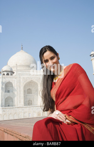 Donna seduta davanti a un mausoleo, Taj Mahal, Agra, Uttar Pradesh, India Foto Stock