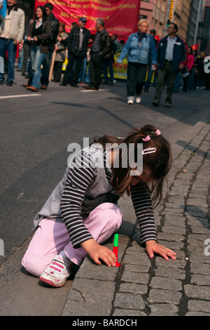Bambini che giocano di fronte di contestatori. Foto Stock