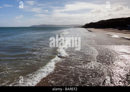 Benllech Isola di Anglesey North Wales UK Europa vista lungo onde sul litorale della spiaggia vuota verso il rosso Wharf Bay Foto Stock