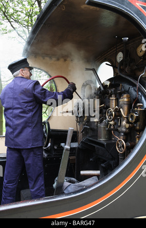 Un driver sul North Norfolk Railway pulizia dell'interno della cabina di un Lancashire e Yorkshire Railway locomotiva a vapore, England, Regno Unito Foto Stock