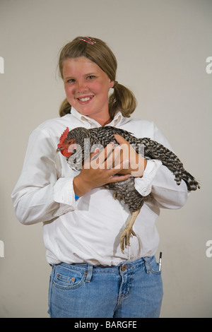 Una giovane ragazza e la sua negata plymouth rock gallina di pollo in 4 h a una fiera della contea Foto Stock