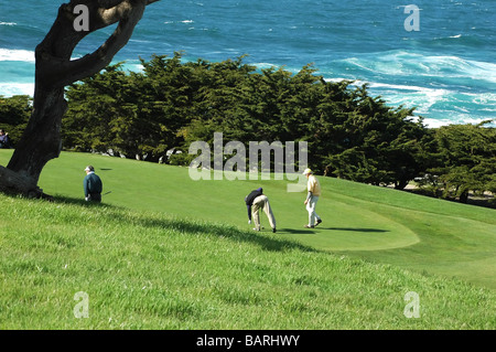 Gli uomini giocare a golf in un campo da golf Oceano Foto Stock