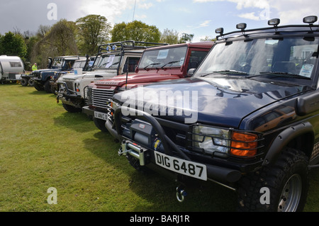 Linea di off road landrovers parcheggiato su un campo. Foto Stock