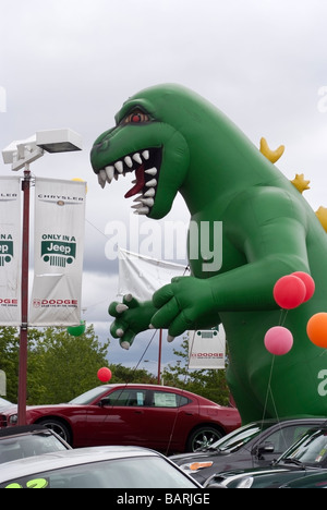 Grande dinosauro gonfiato tra veicoli all'entrata di una Chrysler, Jeep, Dodge auto concessionaria in San Jose, CA Foto Stock