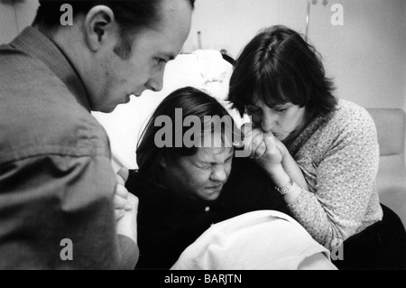 Jenny spinge durante una contrazione. Essa è corredata di sua madre e suo marito durante il suo primo lavoro, Homerton Hospital. Foto Stock