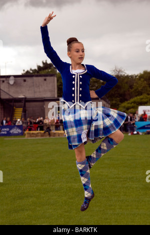 Giovani ragazze nelle tradizionali in tartan blu dress up nell'aria eseguendo Highland Dance Foto Stock