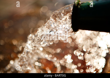 Versare acqua da un rubinetto vicino fino Foto Stock