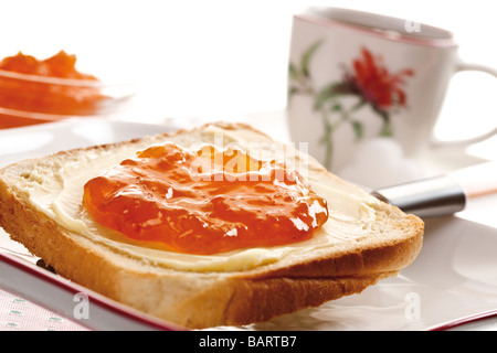 La prima colazione, la fetta di pane tostato con burro e marmellata di arancia, close-up Foto Stock