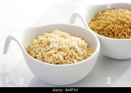 Tipi di riso in ciotole, crudo e cotto, close-up Foto Stock