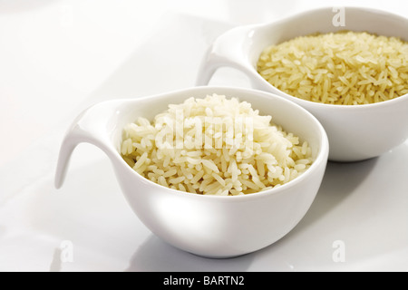 Tipi di riso in ciotole, crudo e cotto Foto Stock