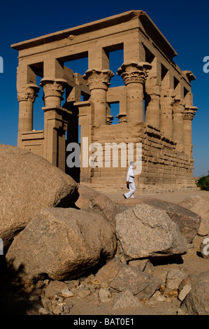 Il poliziotto passeggia accanto al chiosco di Traiano nel tempio di file sull'isola di Agilkia nel bacino idrico della bassa diga di Assuan in Egitto Foto Stock