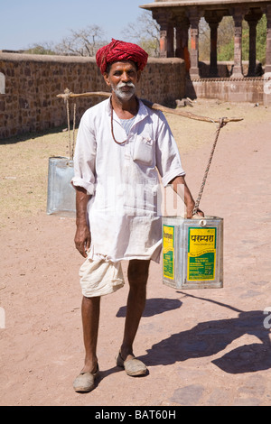 Uomo che trasportano contenitori pieni di acqua, in Ranthambhore Fort, Ranthambhore National Park, Rajasthan, India Foto Stock