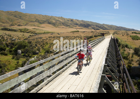 I ciclisti su cinque Mile Creek Bridge Central Otago Rail Trail vicino Hyde Central Otago Isola del Sud della Nuova Zelanda Foto Stock