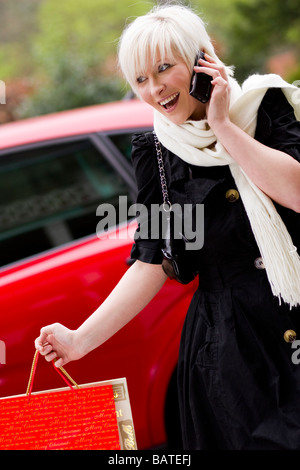 Shopping ragazza in chat sul telefono Foto Stock